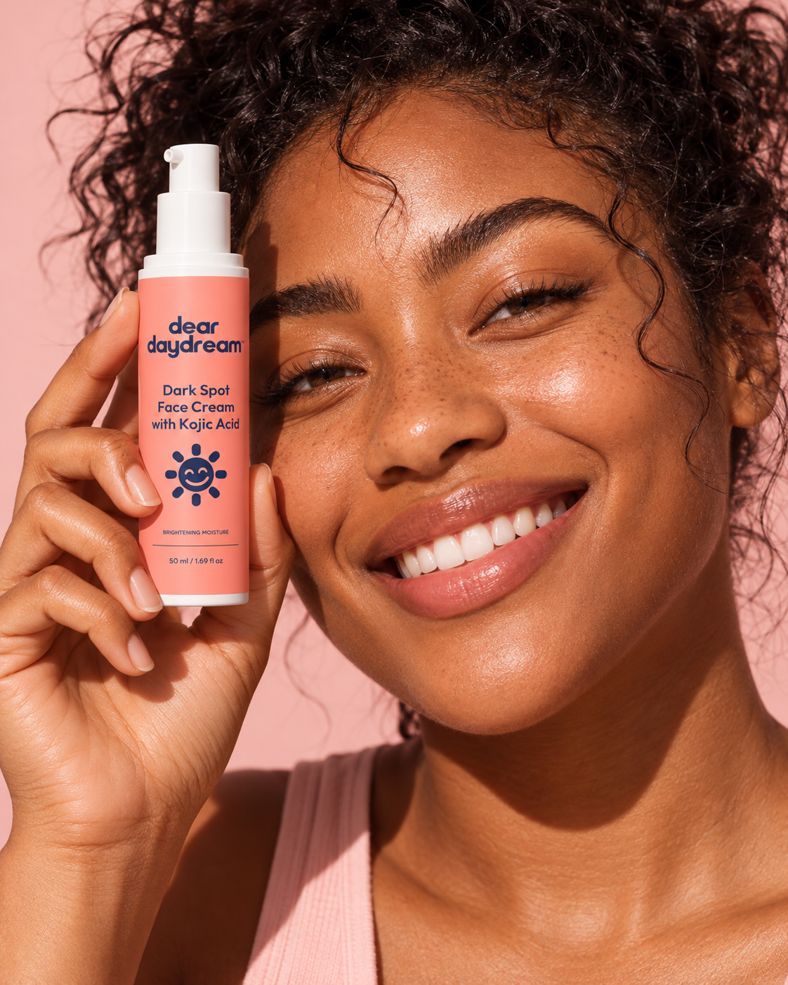 Smiling woman with natural curls holding Dear Daydream Dark Spot Face Cream